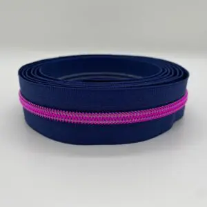 Aufgerollter Reißverschluss Intense Colors Pink Marine mit dunkelblauem Band und metallisierter pinker 6,5-mm-Spiralraupe als Meterware für Taschen und DIY-Projekte.