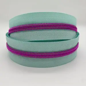 Doppelt aufgerollter Reißverschluss Intense Colors Pink Mint mit mintfarbenem Band und metallisierter pinker Spiralraupe als Meterware für Taschen und Accessoires.