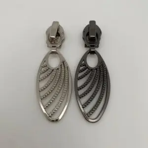 Zipper Grace für 6,5 mm breite Spiralreißverschlüsse im Farbvergleich Gunmetal und Silber – hochwertige Reißverschluss-Schieber mit filigranem Anhänger und Autolock-Funktion.