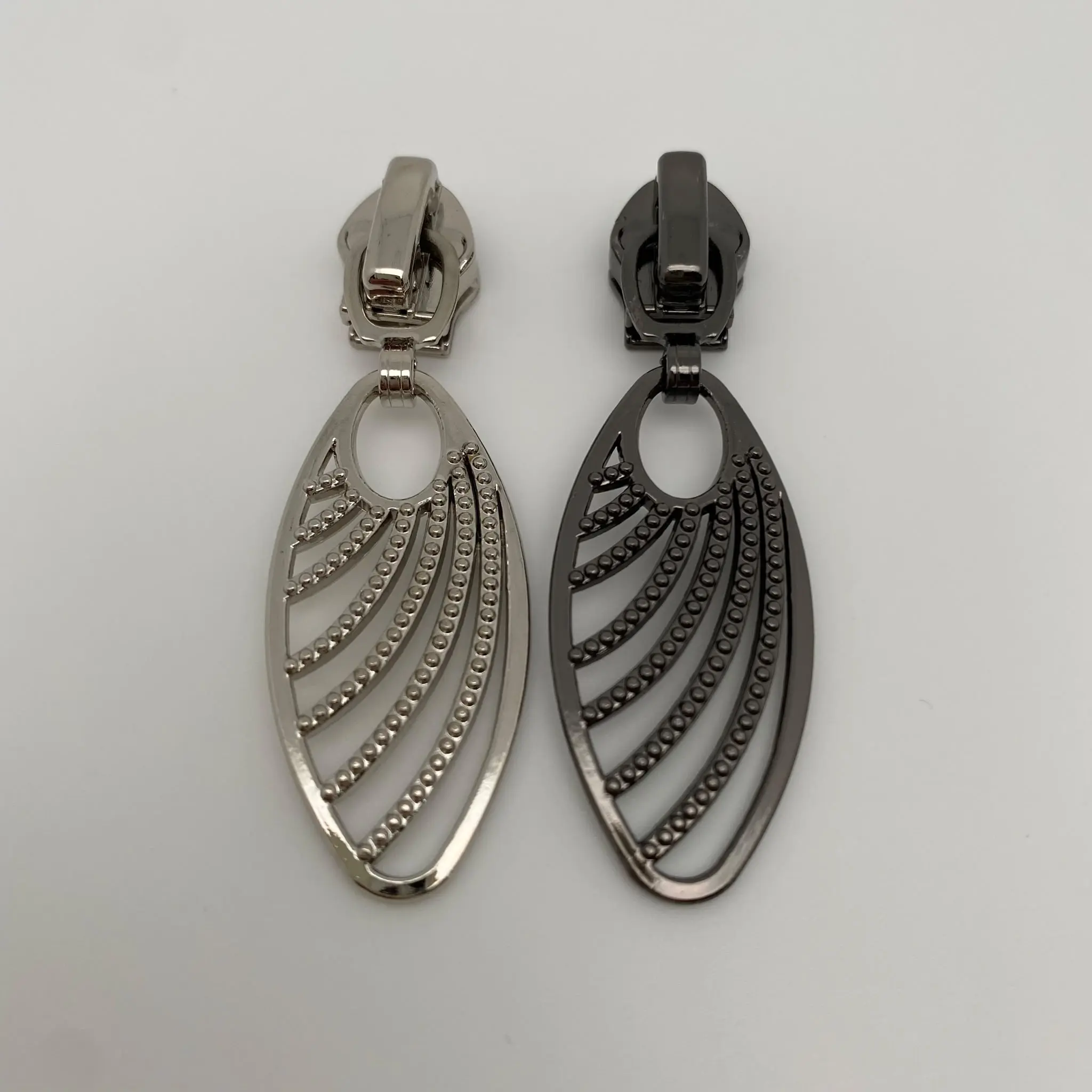 Zipper Grace für 6,5 mm breite Spiralreißverschlüsse im Farbvergleich Gunmetal und Silber – hochwertige Reißverschluss-Schieber mit filigranem Anhänger und Autolock-Funktion.