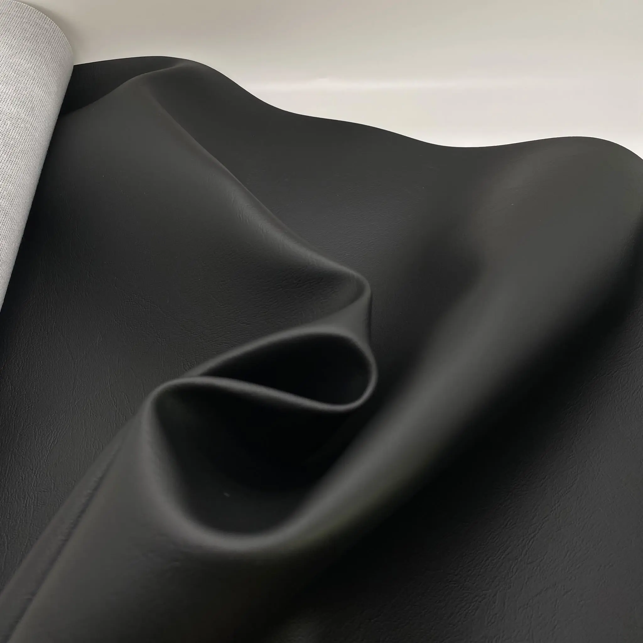 Kunstleder Marina Schwarz drapiert – flexibler Materialfall und matte Oberfläche