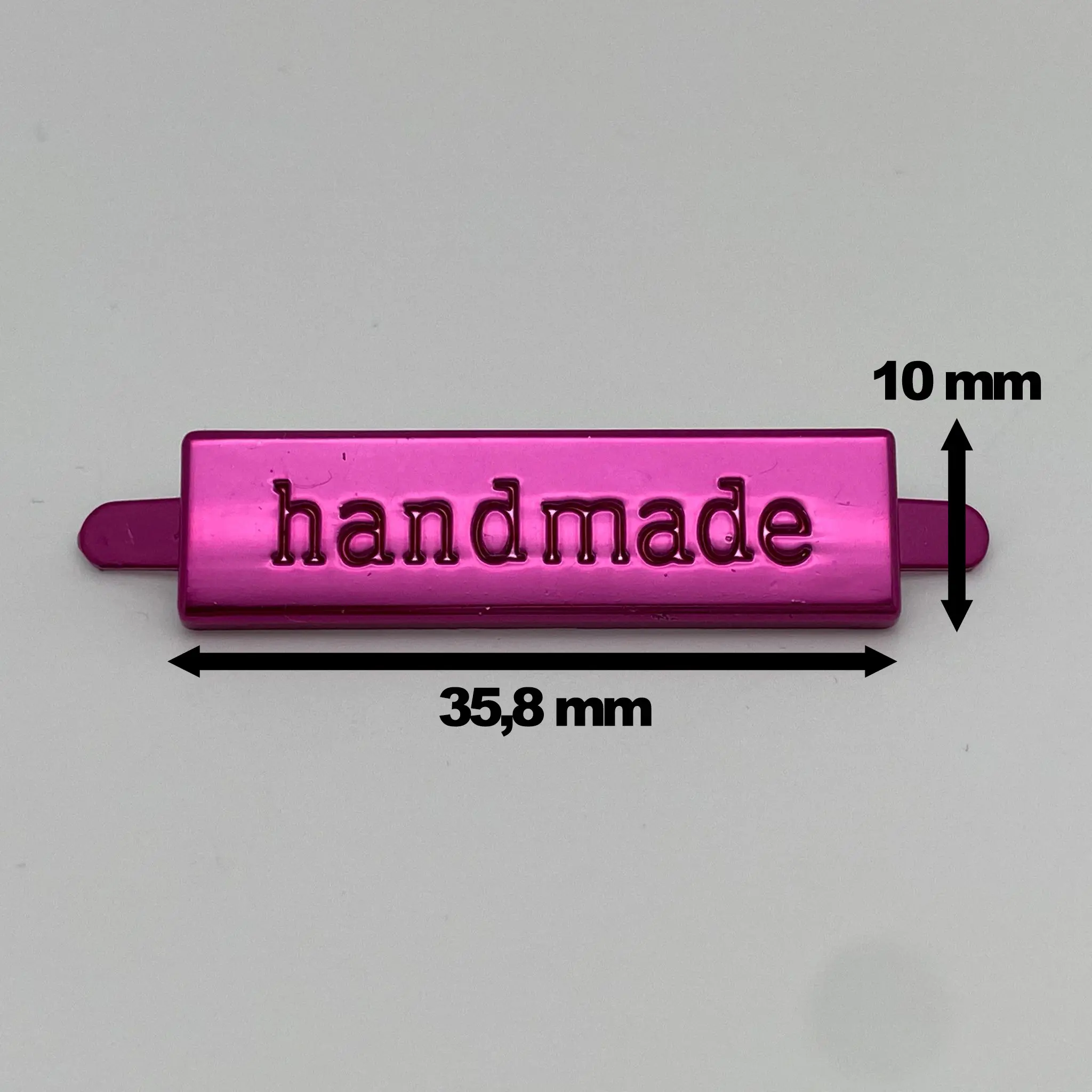 Metalllabel Handmade Pink mit eingezeichneten Maßen von ca. 35,8 mm Breite und 10 mm Höhe